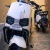 White electric scooter appears to be a Benneng SR model.
